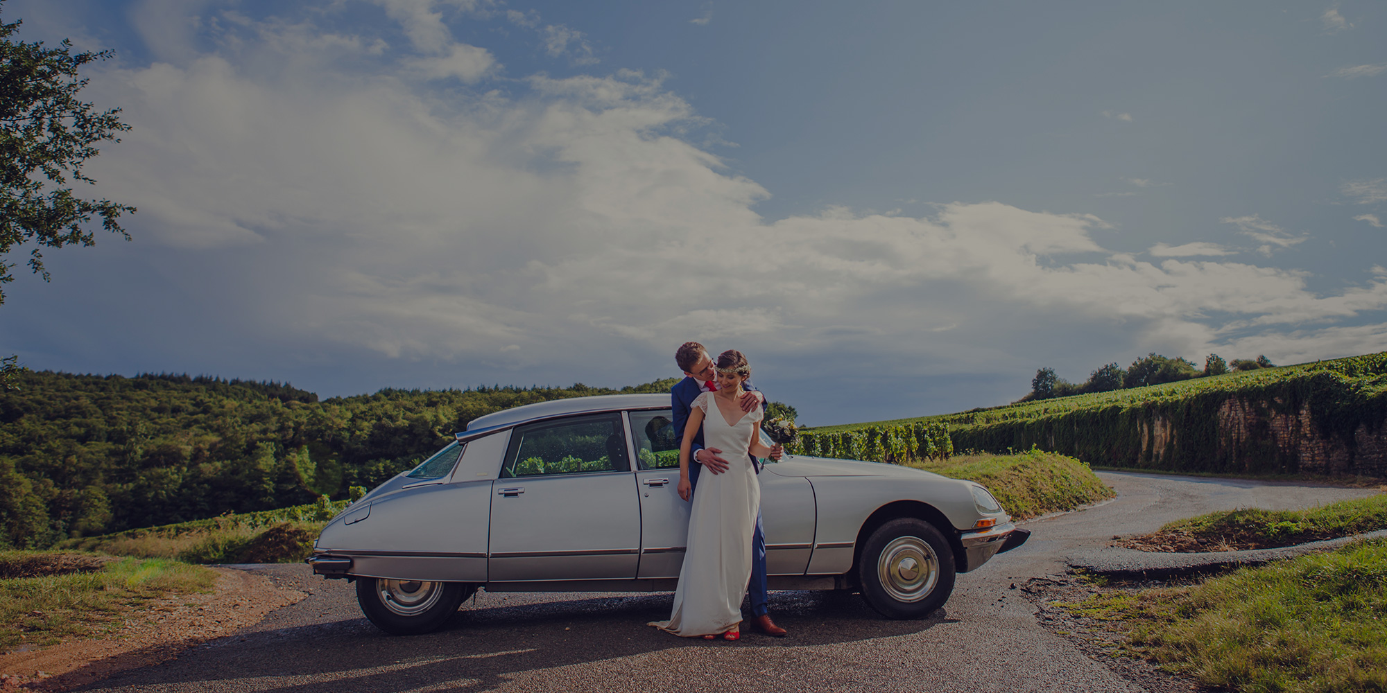 Photographie d'une mariage pendant une séance couple dans les vignes avec voiture vintage à Mâcon