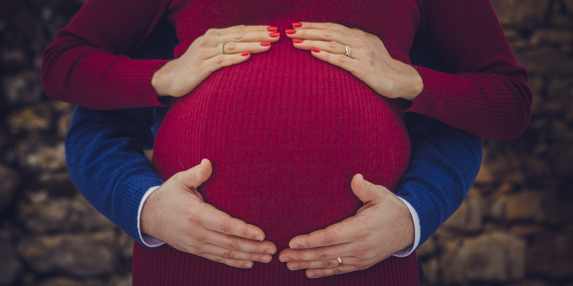 Photographie d'un ventre rond pour une séance grossesse avec le futur papa et la futur maman